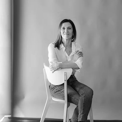 Sofia de Castro Fernandes sentada numa cadeira, de braços cruzados.